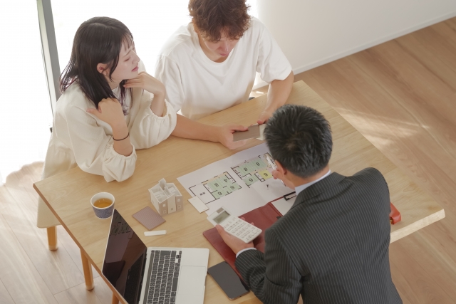 家の間取りを相談している2人とビジネスマン