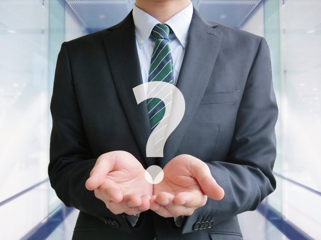 ハテナを持つビジネスマンの手元