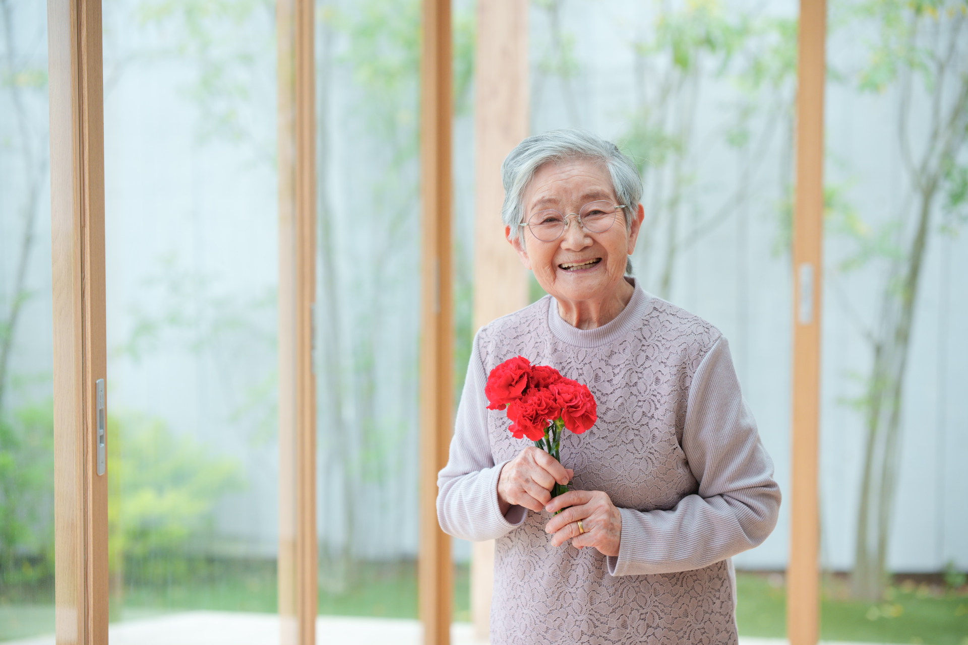 花を持つ笑顔の高齢女性