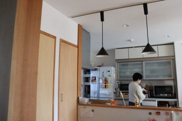 木目調の扉と白い壁に囲まれた明るいキッチン