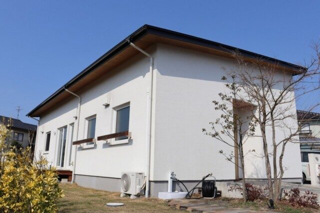庭に面した白い外壁の平屋住宅